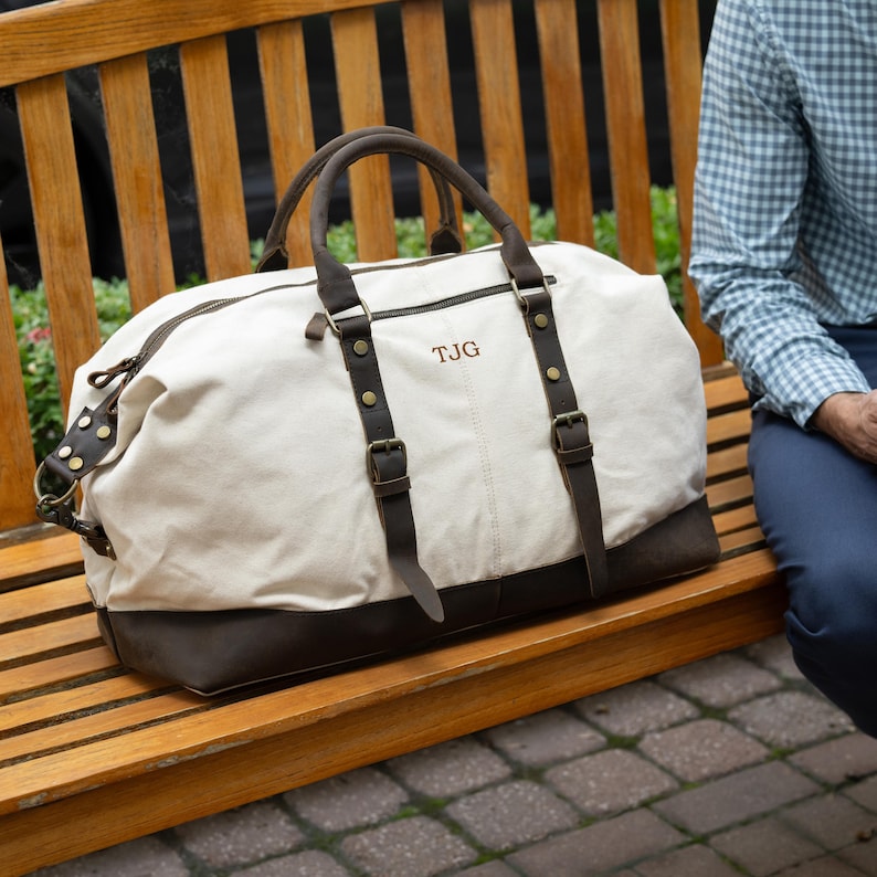 The white langston duffle bag shown on a bench