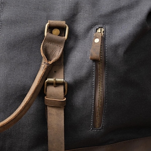 Close-up of leather accents on the charcoal grey langston duffle bag