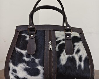 Bolso de mano artesanal de piel de vacuno con pelo de poni blanco y negro con correas de cuero marrón oscuro