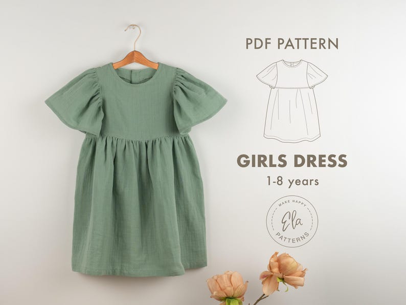 May include: Sage green girls dress with flutter sleeves hanging on a wooden hanger. The dress has a gathered waist and a round neckline. Text on the image reads "GIRLS DRESS 1-8 years" and "PDF PATTERN".