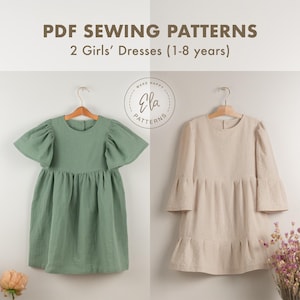 Könnte beinhalten: Zwei Mädchenkleider hängen an Holzbügeln. Das linke Kleid ist salbeigrün mit kurzen, gepufften Ärmeln. Das rechte Kleid ist beige mit langen, ausgestellten Ärmeln. Der Text oben lautet "PDF Sewing Patterns" und "2 Girls' Dresses (1-8 years)".