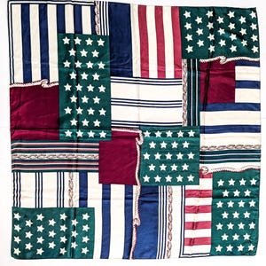 May include: A square silk scarf with a patchwork design featuring patriotic colors and patterns. The scarf incorporates stripes, stars, and solid color blocks in red, white, blue, and green, with rope-like trim.