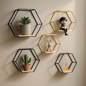 Peut inclure: Cinq étagères murales hexagonales en métal noir et doré avec des tablettes en bois. Les étagères sont décorées de plantes, d'une petite figurine et d'un diffuseur.