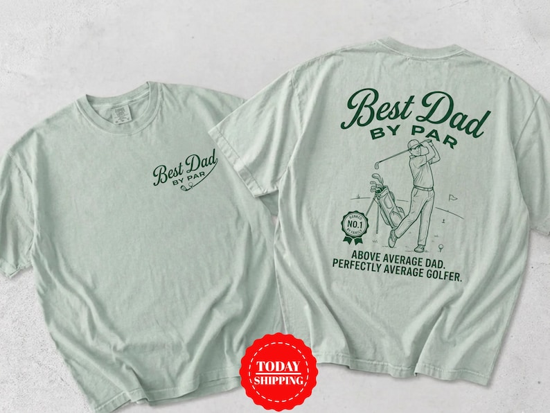 May include: A light sage green t-shirt featuring dark green graphics. The front displays the text Best Dad By Par. The back shows a golfer with a golf bag, a No. 1 badge, and the text Best Dad By Par, Above Average Dad, Perfectly Average Golfer.