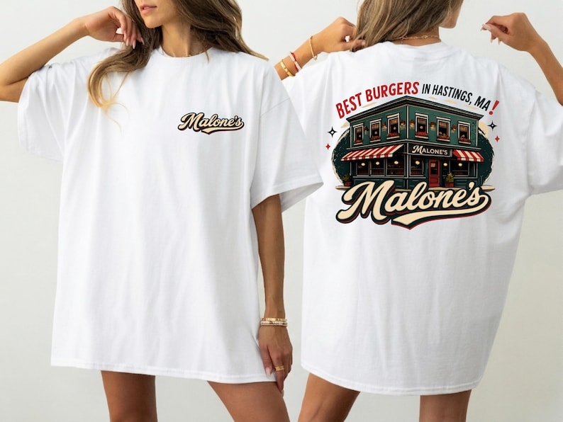 May include: White t-shirt with the text "Malone's" on the front and a graphic on the back. The back graphic features a building with a red and white striped awning, the words "BEST BURGERS IN HASTINGS, MA!" and the name "Malone's".
