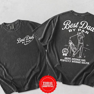 May include: A charcoal gray short-sleeve t-shirt featuring white graphics. The front displays the text "Best Dad BY PAR". The back shows a golfer, a golf bag, a "RANKED NO.1" badge, and the text "Best Dad BY PAR. ABOVE AVERAGE DAD. PERFECTLY AVERAGE GOLFER."