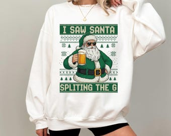 May include: White sweatshirt with a green and white graphic. The graphic features Santa Claus wearing sunglasses and holding a beer, with the text "I SAW SANTA SPLITTING THE G". The design has a festive, ugly sweater style.