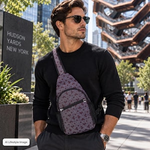 May include: A crossbody sling bag featuring a dark purple and grey geometric square pattern, a front zippered pocket, and an adjustable strap. The bag is worn over the shoulder, resting against the chest, and is made of a durable fabric material.