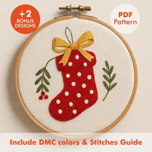 May include: Embroidered Christmas stocking design in a wooden hoop. The red stocking features white polka dots and a yellow bow. Green leaves and the text "+2 BONUS DESIGNS" and "PDF Pattern" are also visible.