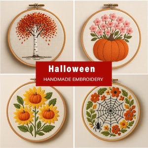 May include: Four circular embroidery hoops featuring seasonal designs: a white birch tree with orange leaves, a pumpkin with pink flowers, three sunflowers with orange centers, and a spider web with a spider surrounded by orange and yellow flowers.