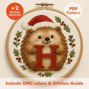 May include: A cross-stitch embroidery hoop featuring a hedgehog wearing a Santa hat and holding a red letter "H". The design includes holly and berries, with text that reads "PDF Pattern" and "+2 Bonus Designs". The text "Include DMC colors & Stitches Guide" is also present.
