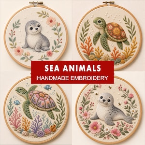 Puede incluir: Cuatro bastidores de bordado circulares de madera con diseños cosidos a mano de animales marinos sobre tela crema. Dos bastidores muestran focas grises rodeadas de flores rosas y vegetación, y dos muestran tortugas marinas entre arrecifes.