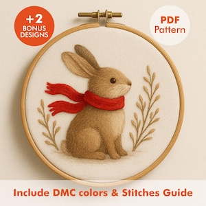 May include: A cross-stitch embroidery hoop featuring a brown rabbit wearing a red scarf. The rabbit is surrounded by embroidered foliage. The text "+2 BONUS DESIGNS" and "PDF Pattern" are visible. The text "Include DMC colors & Stitches Guide" is also present.