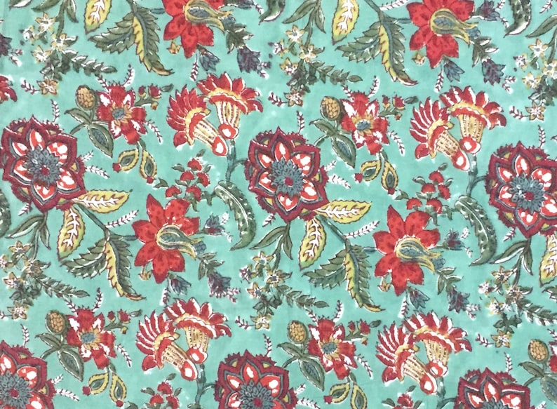 May include: A teal fabric with a repeating floral pattern. The flowers are red, yellow, and green. The fabric has a vintage look.