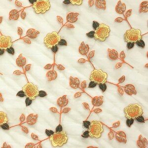 May include: Orange and yellow floral embroidery on a sheer white fabric. The flowers are detailed with sequins and beads.