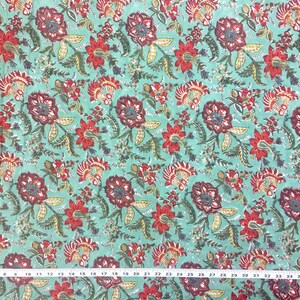May include: Teal fabric with a repeating floral pattern. The flowers are red, burgundy, and yellow with green leaves. The fabric is measured in inches.