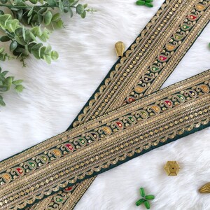 Puede incluir: Borde de tela verde con bordado dorado y lentejuelas de colores. El borde presenta un patrón de paisley y es perfecto para agregar un toque de elegancia a cualquier proyecto.