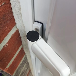 May include: White window sash with a black rubber seal and a white handle. The handle is attached to a white metal frame with a black screw.