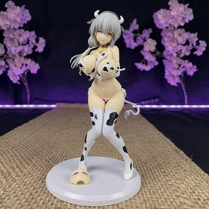 Puede incluir: Una taza de cerámica blanca con un asa negra y el texto "But First, Coffee" en negrita negra. La taza se encuentra sobre un fondo borroso, resaltando su diseño limpio.