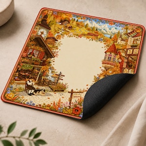 May include: A square mouse pad featuring a detailed autumn village scene with a central cream-coloured space. The illustration includes timber-framed buildings, a clock tower, a person playing a horn, a dog, and a sign that reads Welcome.