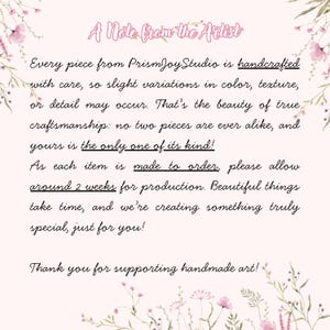 Puede incluir: Un fondo rosa claro con detalles florales y texto que dice "A Note from the Artist". El texto describe art&iacute;culos hechos a mano de PrismJoyStudio, enfatizando variaciones &uacute;nicas y un tiempo de producci&oacute;n de 2 semanas.