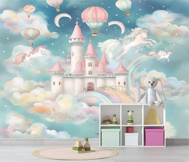 Op de afbeelding: Een grillige muurschildering met een sprookjeskasteel met roze torentjes, eenhoorns en luchtballonnen tegen een pastelkleurige lucht. Een witte plank bevat speelgoed en opbergdozen.