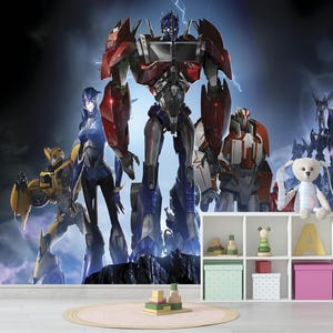 Pode incluir: Um mural de papel de parede com personagens Transformers em uma pose dinâmica contra um céu tempestuoso. Os robôs são em tons de vermelho, azul, amarelo e prata. Uma prateleira branca com brinquedos e caixas de armazenamento está em primeiro plano.