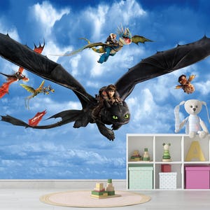 May include: A colourful wall mural depicting characters from the film "How to Train Your Dragon". Dragons fly across a blue sky with clouds. A white shelf with toys and a stuffed bunny is in the foreground, with a round rug on the floor.