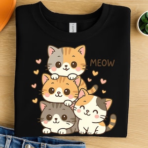 May include: Black sweatshirt with a cartoon design of four cats in orange, grey, and white, with pink hearts and the word "MEOW". The cats have smiling faces and are stacked on top of each other.