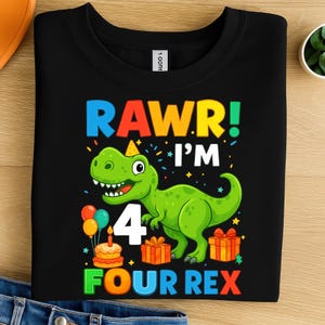 Op de afbeelding: Zwart sweatshirt met ronde hals en kleurrijke afbeelding. Het ontwerp toont een groene dinosaurus met een feesthoed, het nummer 4 en de tekst "RAWR! I'M FOUR REX". Inclusief ballonnen, een taart en ingepakte cadeaus.