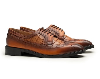 May include: A pair of brown leather dress shoes with a textured, checkered design on the vamp. The shoes have a classic wingtip style with decorative perforations and dark brown laces. The soles are black.