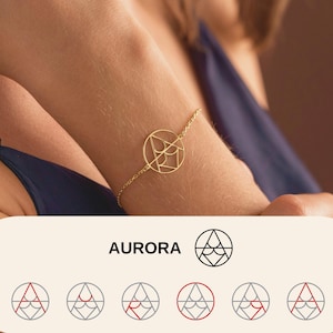 May include: A gold-colored bracelet with a geometric design is worn on a wrist. The bracelet features a circular pendant with an intricate pattern. The word "AURORA" is displayed in black text below the bracelet, along with a logo.