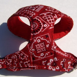 May include: Red and white bandana dog harness with adjustable straps and a buckle closure.