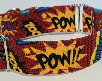 May include: A red dog collar with a comic book style design. The collar features yellow and black "POW!!" and "ZOO" text in starburst shapes, with blue and purple accents. The collar has silver metal hardware.