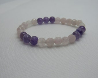 May include: A bracelet made of pink and purple beads. The beads are round and smooth. The bracelet is made of natural stones.