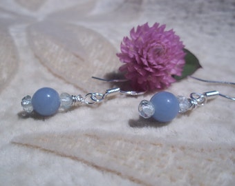 May include: A pair of silver earrings with a light blue gemstone bead and clear crystal accents.