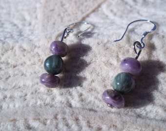 May include: A pair of silver earrings with three purple and green gemstone beads on each earring.