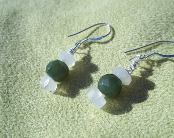 May include: A pair of silver earrings with green and white gemstone beads. The earrings have a simple design and are perfect for everyday wear.
