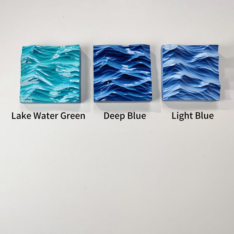 May include: Three square art pieces with textured wave designs. The pieces are in shades of Lake Water Green, Deep Blue, and Light Blue. The text below each piece reads "Lake Water Green", "Deep Blue", and "Light Blue".