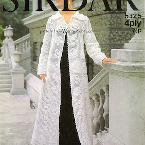 Könnte beinhalten: Ein weißer Häkelcardigan mit einem langen, offenen Vorderteil und einem zarten Spitzenmuster. Der Cardigan wird über einem schwarzen Kleid getragen und das Model steht vor einer Steintreppe. Die Muster Nummer ist 5325 und das Garn ist 4-fädig.