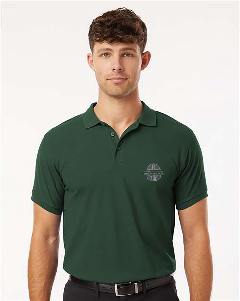 K&ouml;nnte beinhalten: Dunkelgr&uuml;nes Poloshirt mit kurzen &Auml;rmeln und Kragen. Das Shirt hat ein kleines Emblem auf der Brust mit dem Text "THIS IS THE WAY". Das Shirt ist aus einem weichen Material und hat eine klassische Passform.