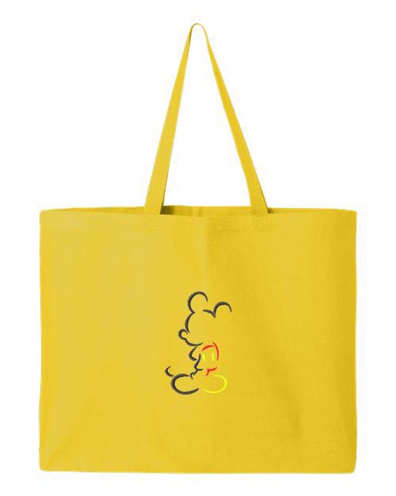 May include: Yellow tote bag with black, red, and yellow Mickey Mouse outline design. The bag has long yellow handles and is made of a solid yellow material. The tote bag is a simple, yet stylish accessory.