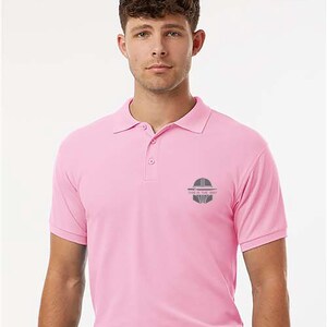 K&ouml;nnte beinhalten: Hellrosa Poloshirt mit kurzen &Auml;rmeln und Kragen. Das Shirt hat eine kleine graue Grafik und den Text "THIS IS THE WAY" auf der linken Brust. Das Shirt ist aus einem weichen Material.