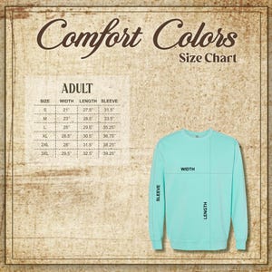 May include: A light teal Comfort Colors sweatshirt with a size chart for adult sizes. The chart shows measurements for width, length, and sleeve length in inches. The text "Comfort Colors" is at the top.