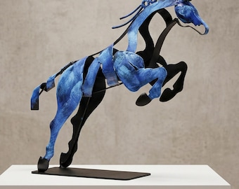 May include: A metal sculpture of a horse in a leaping pose, featuring a textured blue finish on the body and mane, contrasted with solid black metal legs and a black rectangular base, capturing a dynamic and fluid sense of motion.