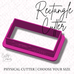 May include: A pink plastic rectangle cookie cutter. The cutter is on a white background with a pink and white pattern. The text "Rectangle Cutter" is written in black cursive above the cutter.