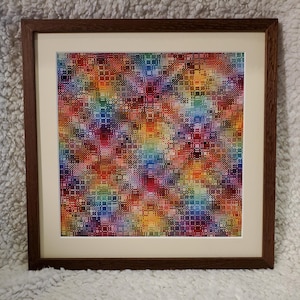 Può includere: Un ricamo a punto croce quadrato caratterizzato da un vivace motivo geometrico multicolore con un disegno a griglia di rombi ripetuto. L'opera è racchiusa in una cornice di legno marrone scuro con un bordo passe-partout color crema.