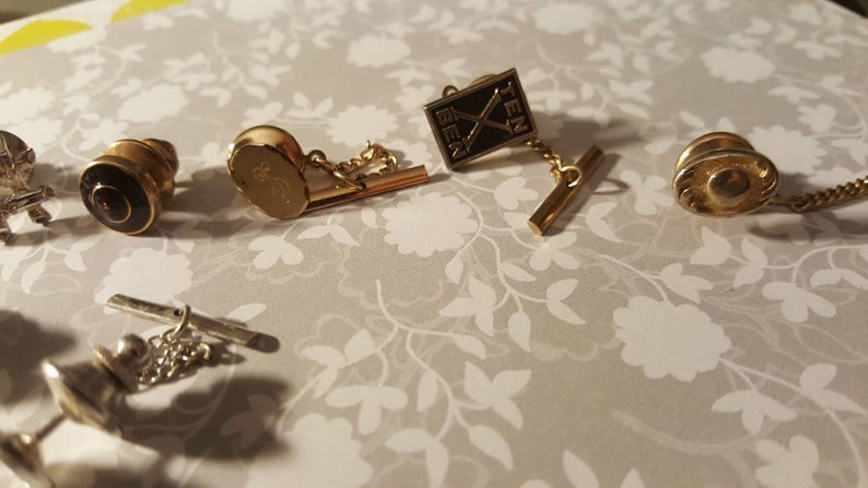 Eleven men/'s tie tacks all in a row