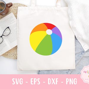 May include: White tote bag featuring a colorful beach ball design. The beach ball is segmented into red, orange, yellow, green, blue, and purple sections. The bag also has the text "SVG - EPS - DXF - PNG".