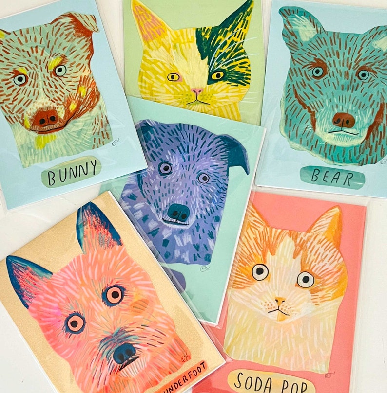 May include: A collection of colorful art prints featuring stylized animal portraits. The prints include a dog labeled "Bunny", a cat, a bear, a dog labeled "Underfoot", a purple dog, and a cat labeled "Soda Pop". Each print has a unique color palette.